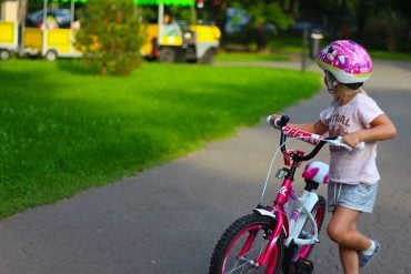 This shows a young girl on a bike