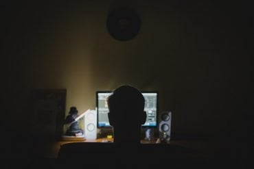 This shows a person in front of a computer at night