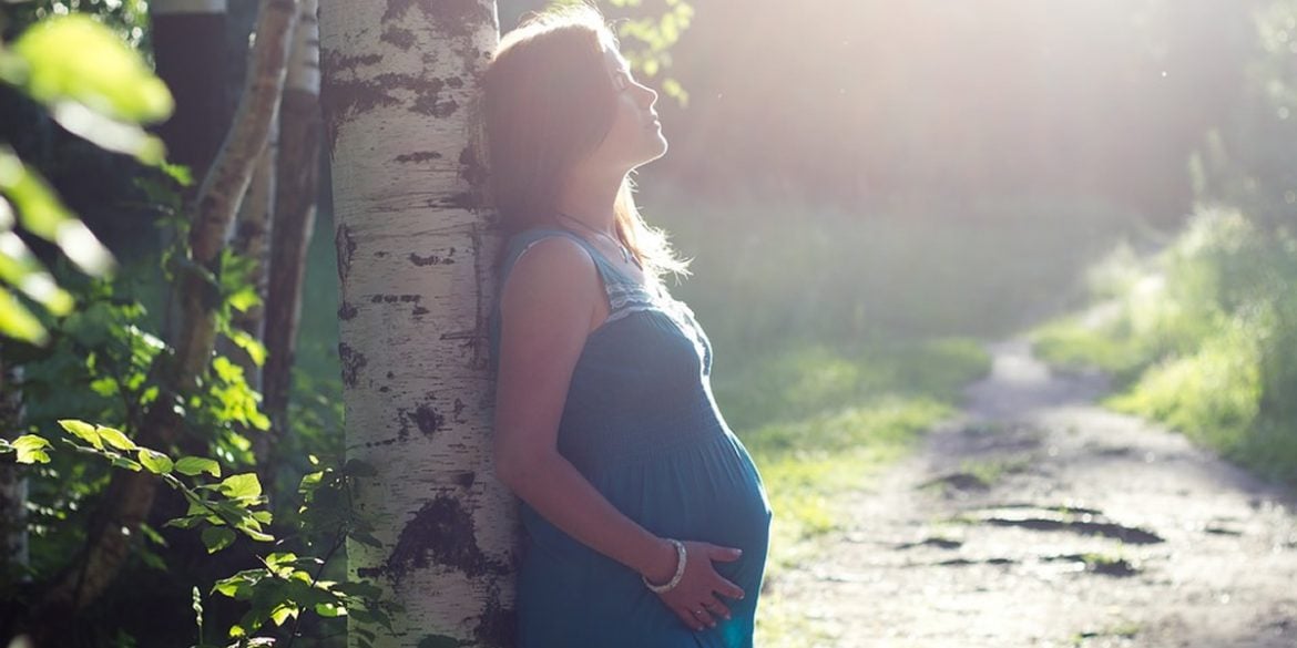 This shows a pregnant woman in nature