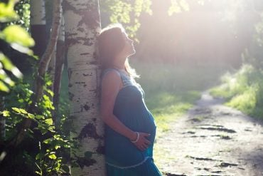 This shows a pregnant woman in nature