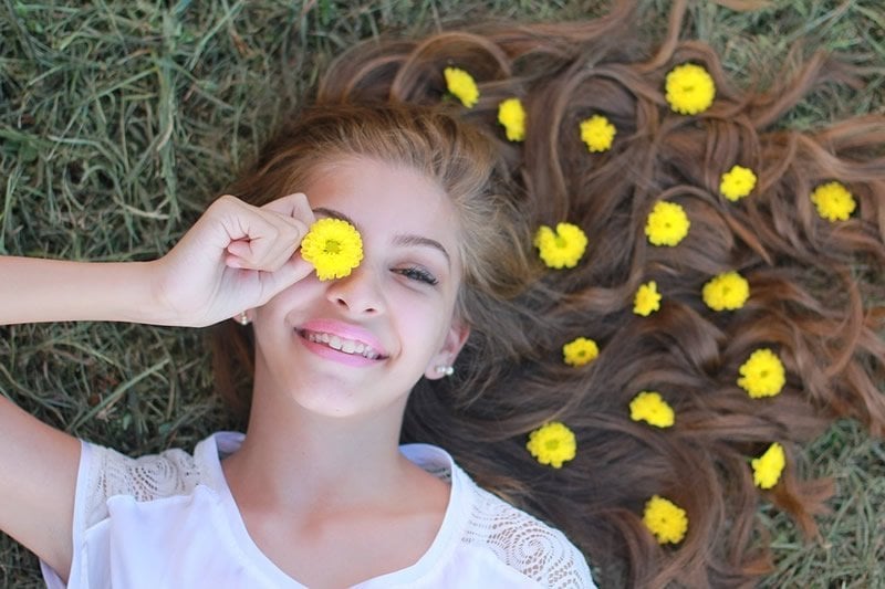 This shows a teenage girl with flowers in her hair