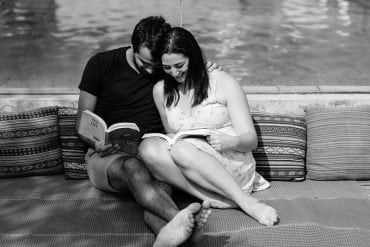 This shows a happy couple reading by a lake