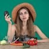 This shows a woman holding up veggies