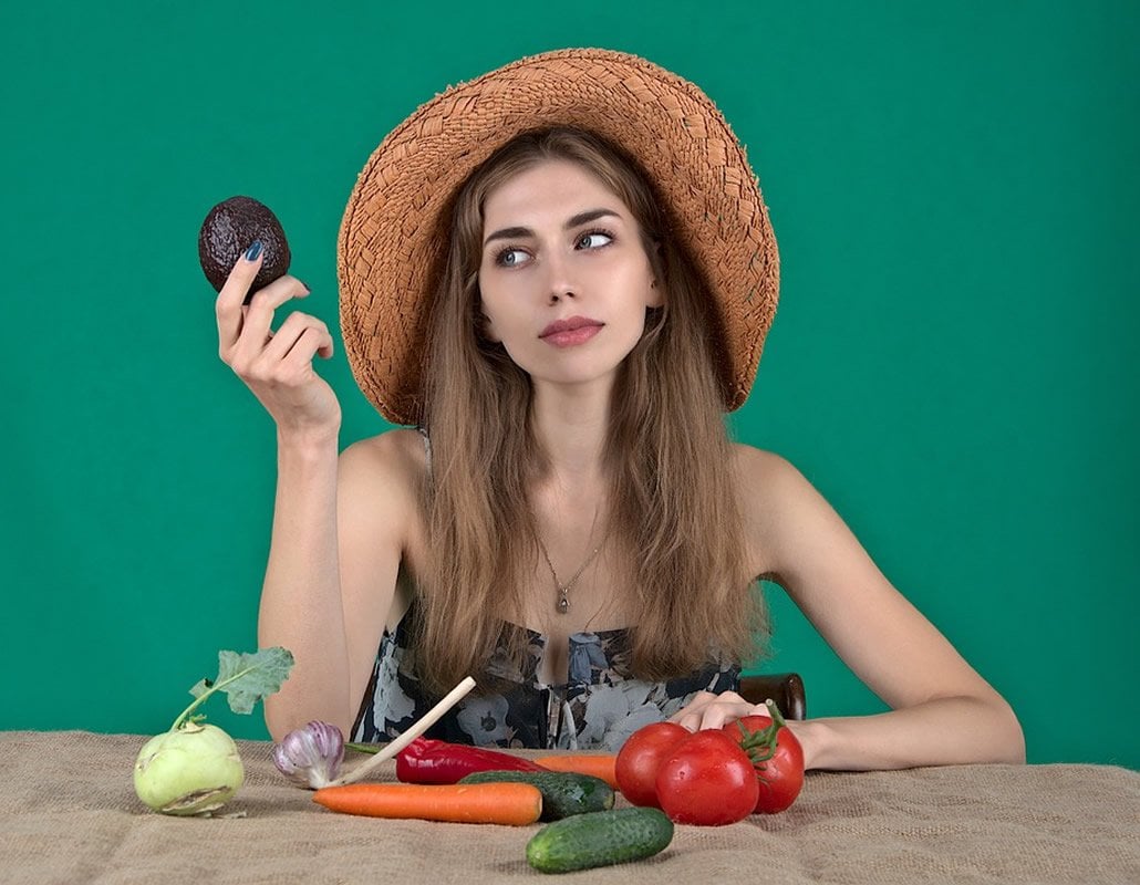 This shows a woman holding up veggies