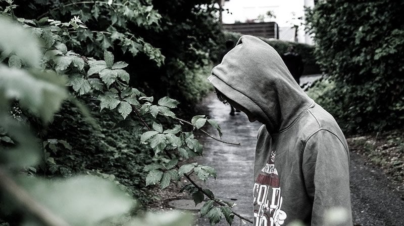 This shows a depressed looking man wearing a hoodie to cover his face