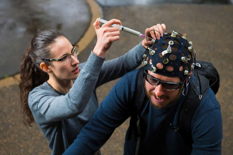 This shows the researcher placing an EEG cap on a test subject