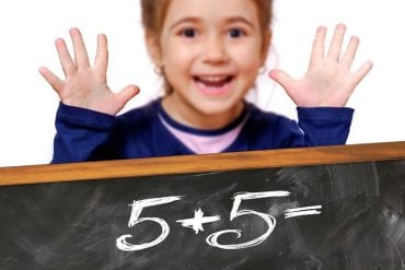 This shows a child with a chalk board full of numbers