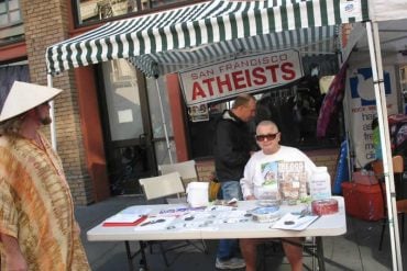 This shows a person at an atheist booth
