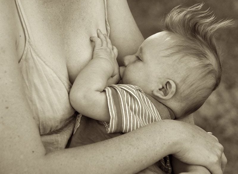 This shows a mother breastfeeding her baby