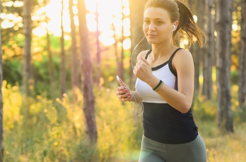 This shows a woman running while listening to music on headphones