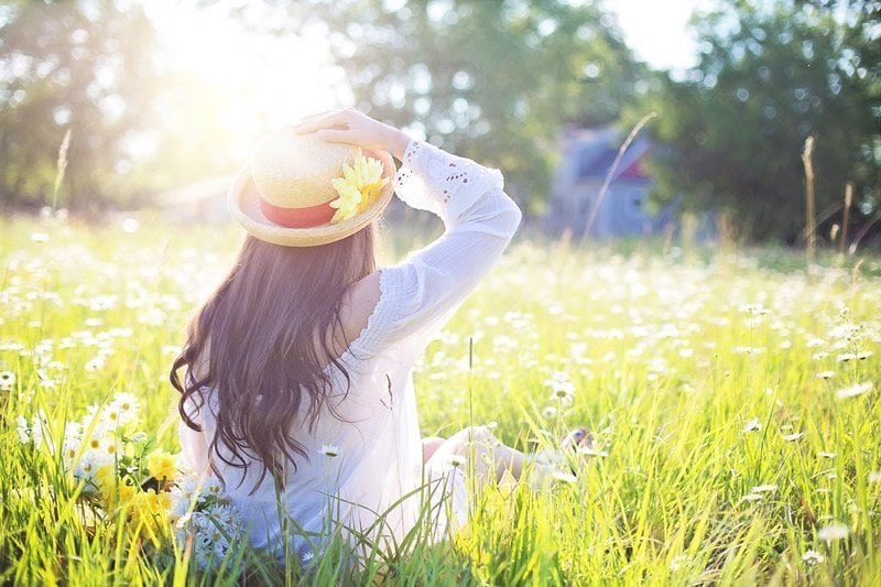 This shows a woman sitting in a field