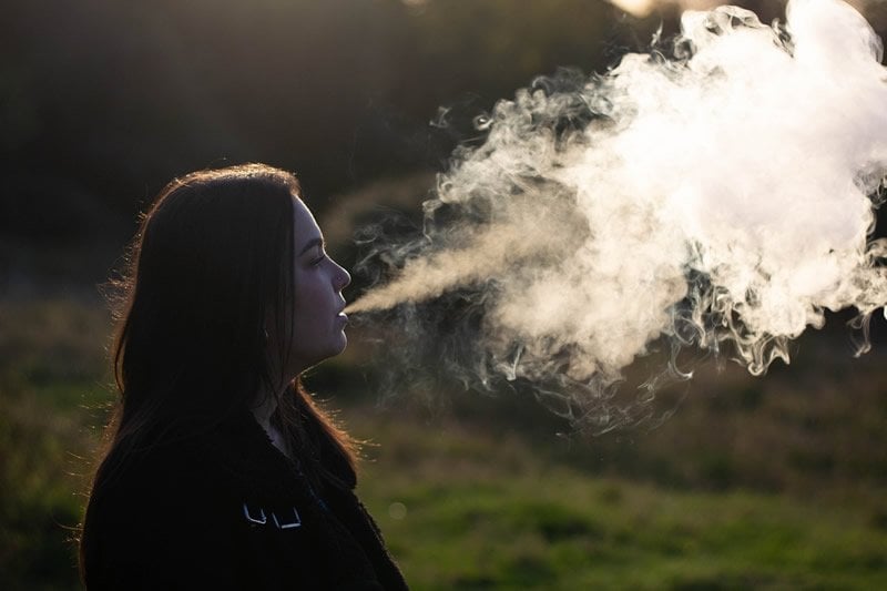 This shows a woman vaping