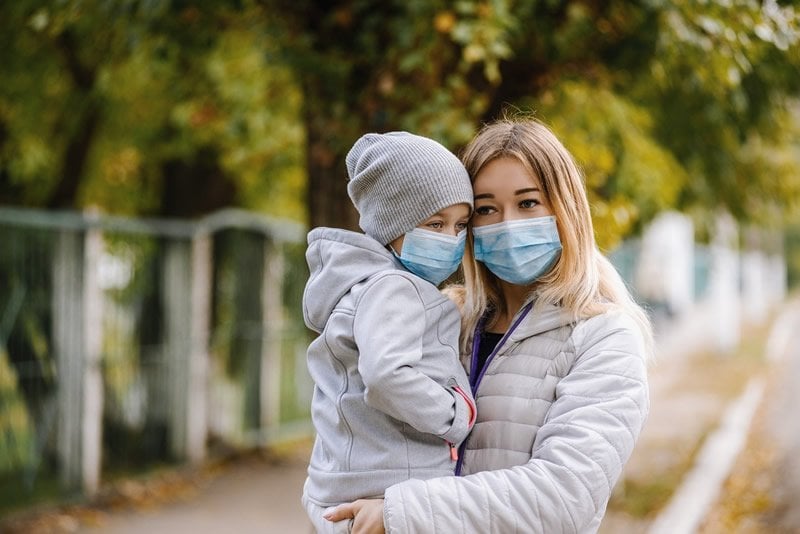 This shows a woman and child in surgical masks