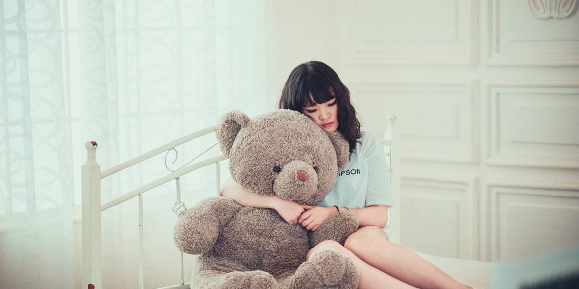 This shows a teenage girl and a teddybear
