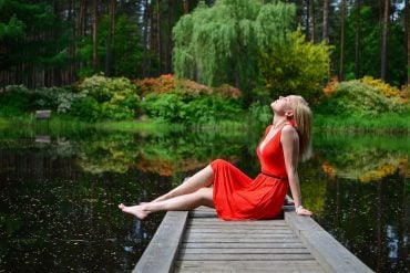 This shows a woman relaxing by a lake