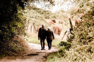 This shows an old couple walking down a lane