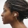 This shows a woman with the tVNS device in her ear
