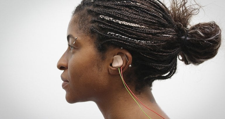 This shows a woman with the tVNS device in her ear