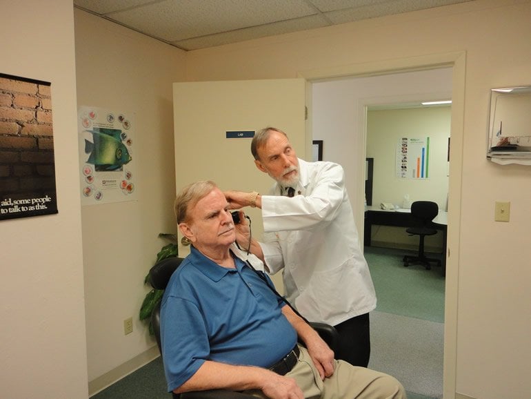 This shows a man getting a hearing test
