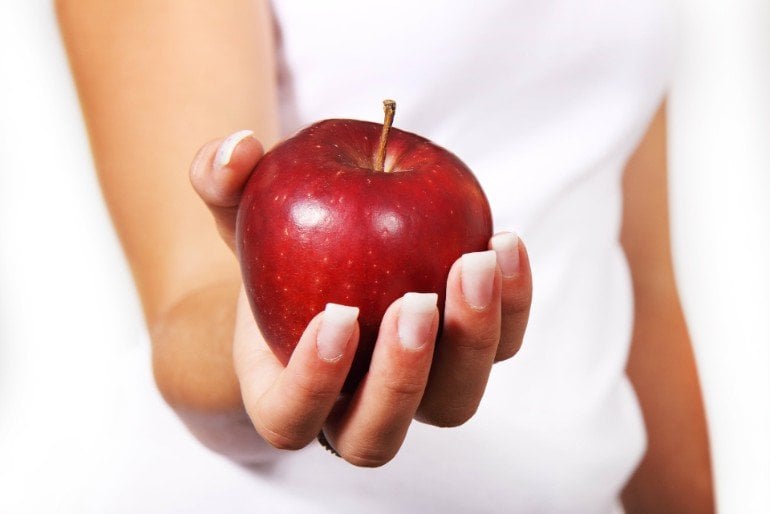 This shows a woman holding an apple