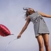 This shows a happy woman with a heart balloon