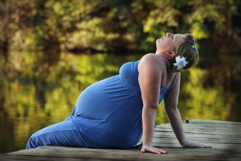 This shows a pregnant woman sitting in the sun