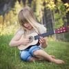 This shows a little girl playing a guitar