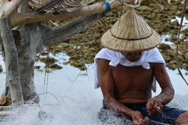 This shows a man fixing a fishing net