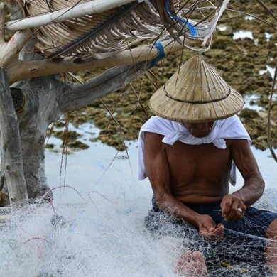 This shows a man fixing a fishing net
