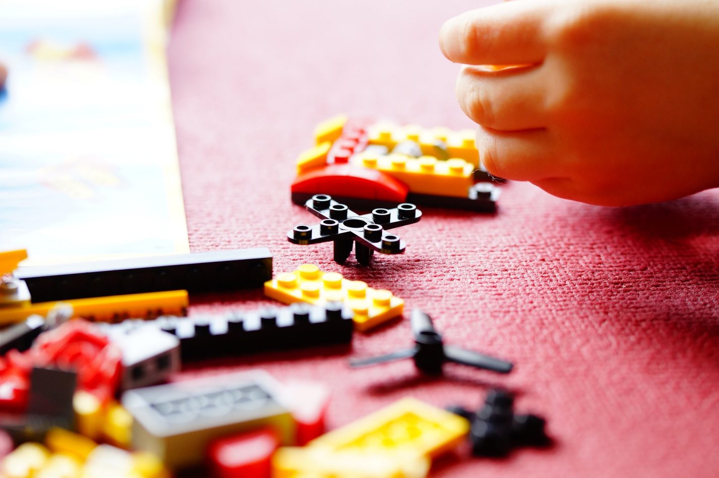 The image shows a child playing with lego blocks
