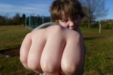 This shows a little boy with his fist out like he is punching