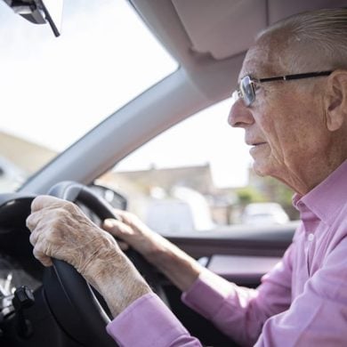 This shows an older gentleman driving a car