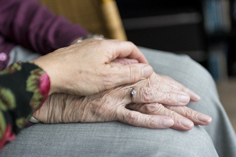 This shows someone holding an older lady's hands