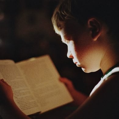 This shows a boy reading a book