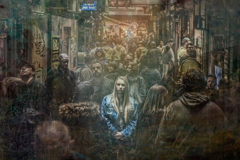 This shows a woman standing alone in a crowd