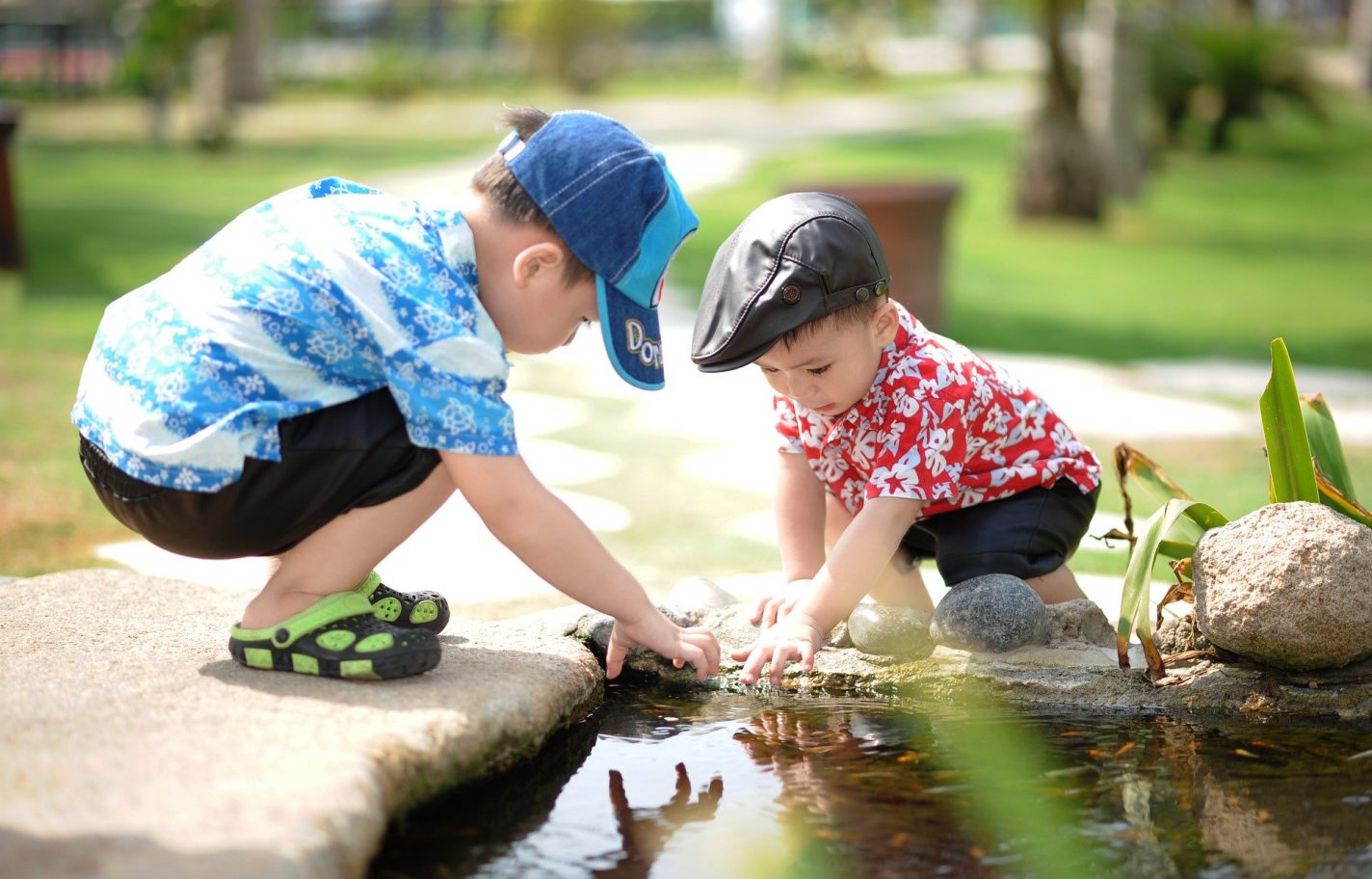 This shows two little boys playing in a stream