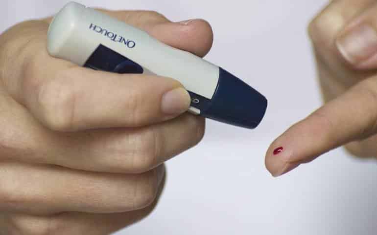 This shows someone performing a finger prick blood test