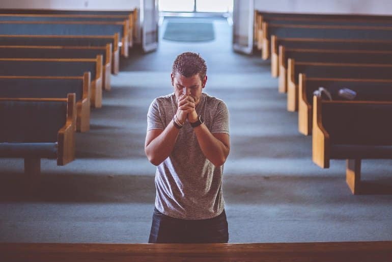 This shows a man praying in a church