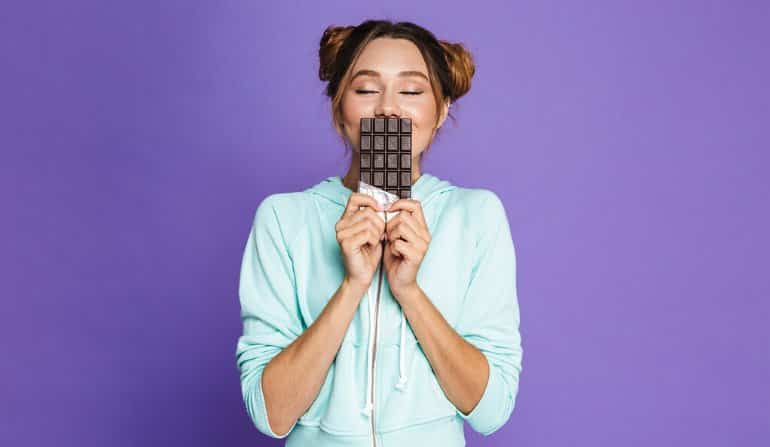 This shows a woman smelling a bar of chocolate