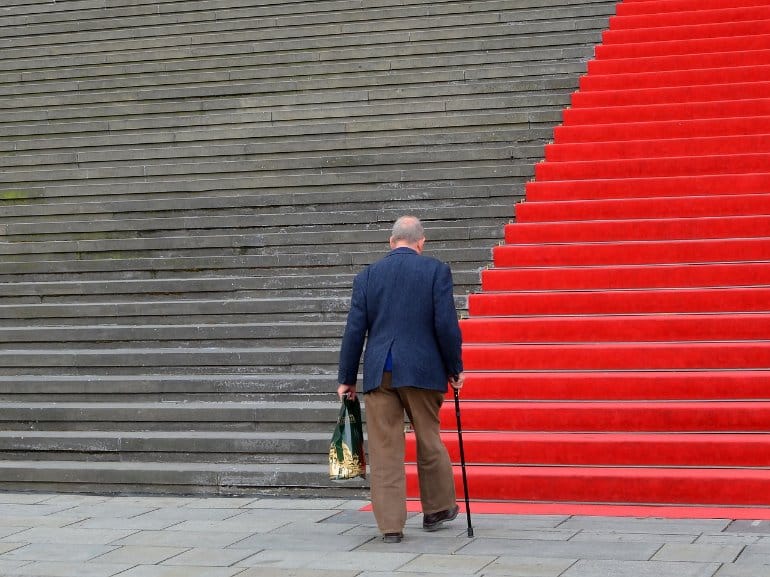 This shows an older man walking up some steps