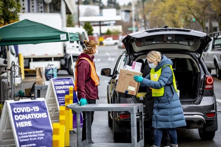 This shows a lady donating items to a COVID donation center