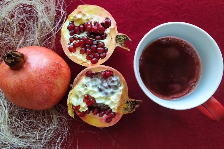 This shows a pomegranate and a mug of juice