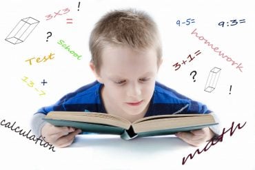 This shows a little boy reading a book, surrounded by math symbols, sums and words associated with math