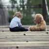 This shows a little boy and a teddy