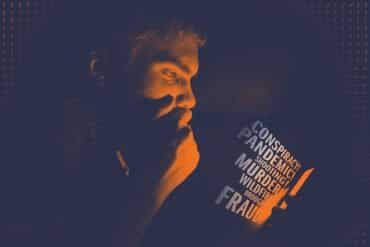 This shows a man reading a book with the word "conspiracies" written on the cover