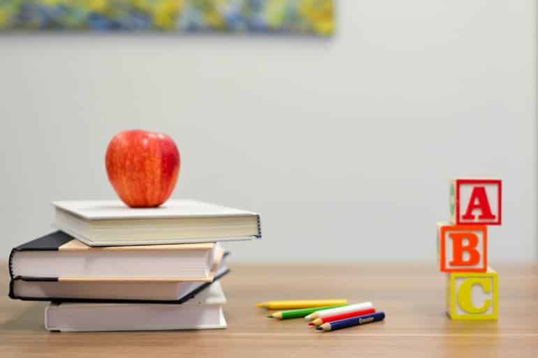 This shows school books and building blocks on a desk