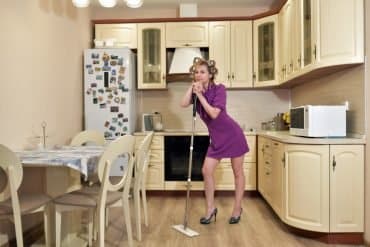 This shows a lady mopping her kitchen floor