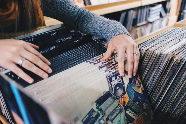 This shows a woman flipping through records in a record store