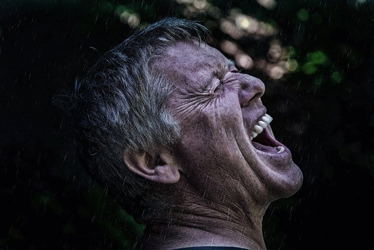 This shows a man screaming in the rain