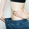 This shows a thin lady holding out an oversized pair of jeans